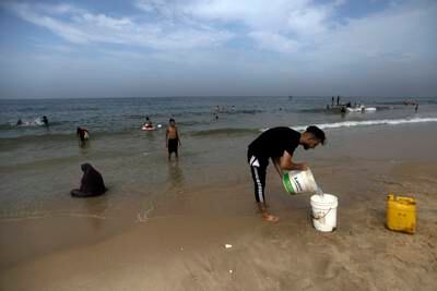 Palestinians gather at the beach in Deir Al Balah, central Gaza, to bathe and clean their clothes. AP