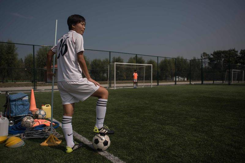 A student stands on the sideline of a women's football training session at the Pyongyang International Football School. Ed Jones / AFP