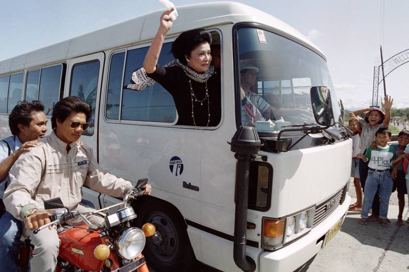 Imelda Marcos waves a white handkerchief as her motorcade arrives in the home town of former president Ferdinand Marcos, in Laoag, 1991. AFP