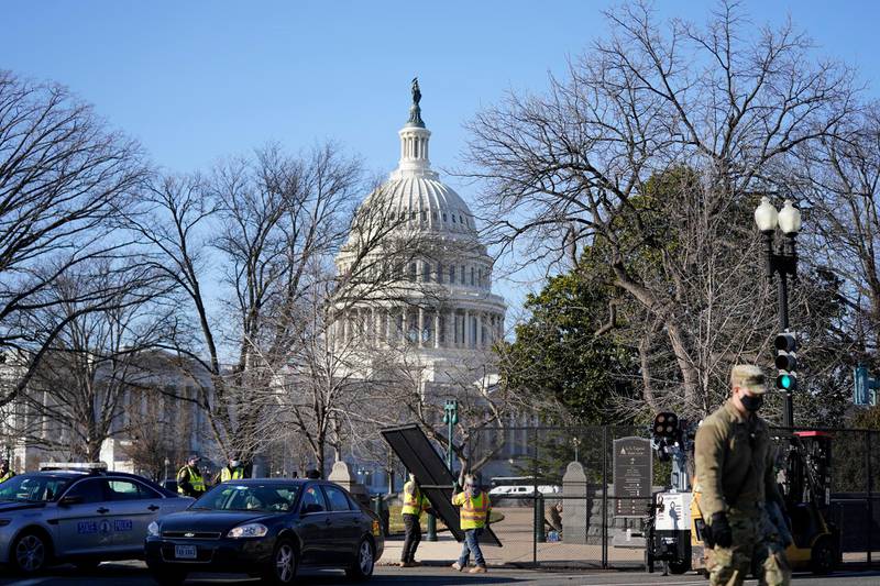 Workers install no-scale fencing around the US Capitol. AP Photo