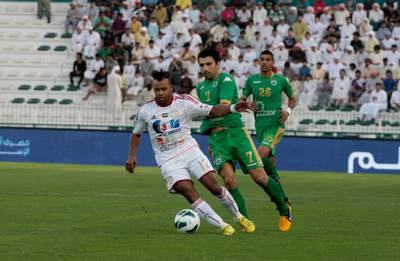 Dubai, United Arab Emirates - April 15, 2013.  Luiz Fernando Da Silva ( no 12 of Al Jazira in white uniform ) in action against Haydarov Azizbek ( no 7 of Al Shabab in green uniform ) as Hassan Ibrahim ( no 26 of Al Shabab ) looks on at their ongoing match for the Etislat Pro League.  ( Jeffrey E Biteng / The National )