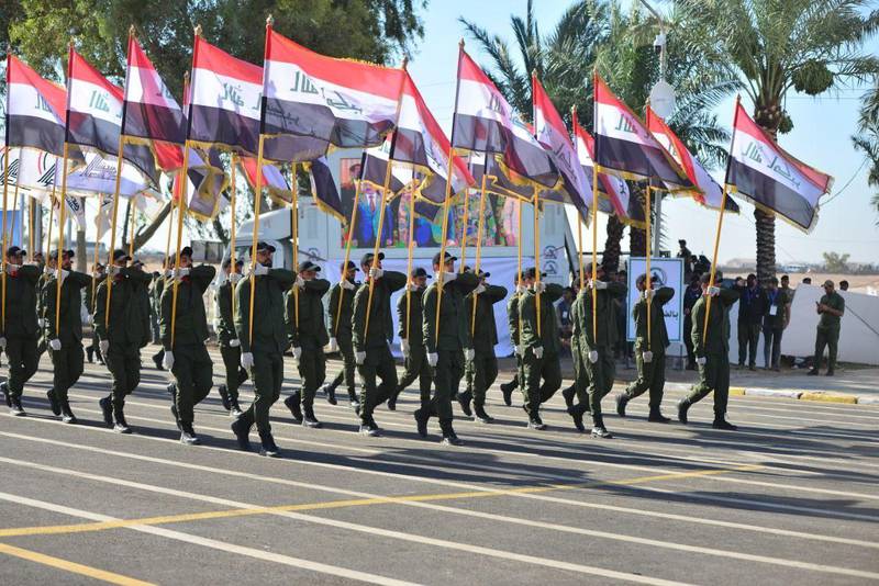 Members of Iraq's Popular Mobilisation Forces take part in a parade to mark the seventh anniversary of the organisation's founding at Camp Ashraf in Diyala province. AFP