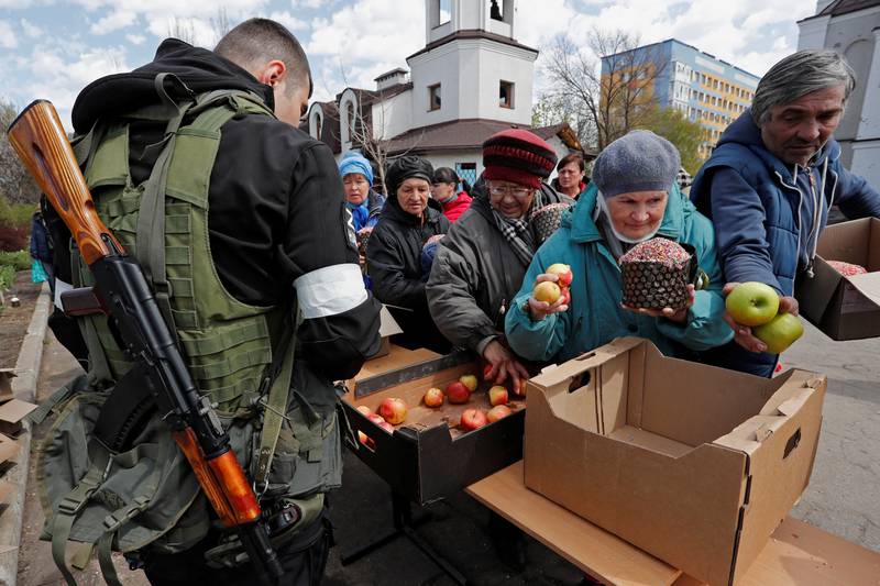 Residents receive Easter cakes and apples handed out by pro-Russian troops on Easter Day at the Svyato-Troitsky Church in the southern port city of Mariupol. Reuters