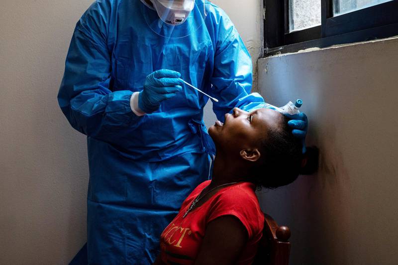 A healthcare worker prepares to take a nasal swab on an Ethiopian woman to test for COVID-19. Finbar Anderson for The National