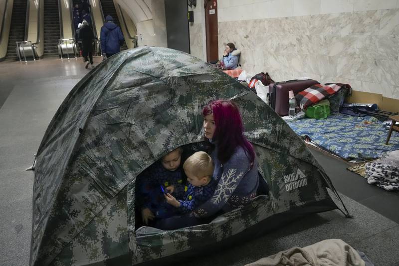 A woman and her children sit in a tent in the Kyiv subway, using it as a bomb shelter. AP