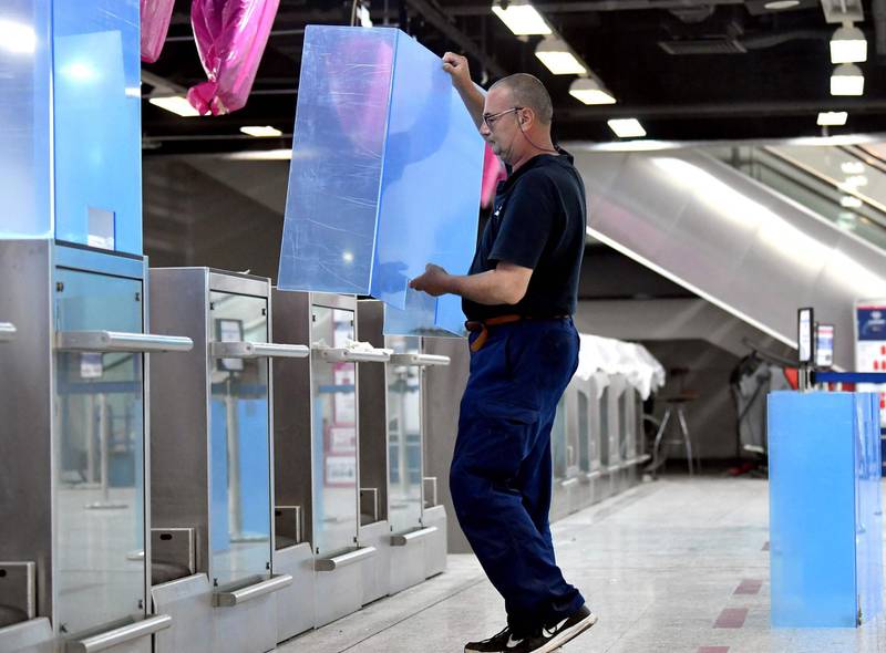 An employee installs plexiglass shields on check-in counters at Sarajevo International Airport in Bosnia. AFP