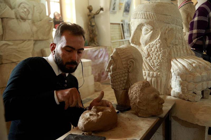 Saad Rahim a sculptor works on artifacts figures destroyed by the Islamic State group before being defeated by Iraqi forces, in a gallery on al-Mutanabi Street in central Baghdad, Friday, Jan. 15, 2021. (APPhoto/Hadi Mizban)
