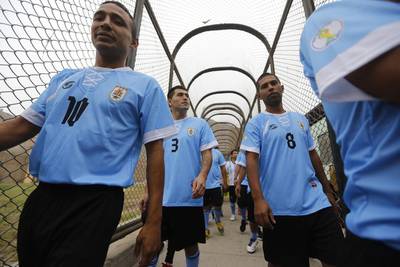 Prisoners, wearing jerseys in the colours of the Uruguay national football team, participate in their own prisoner World Cup at the Castro-Castro prison in Lima on Monday. Mariana Bazo / Reuters / June 2, 2014