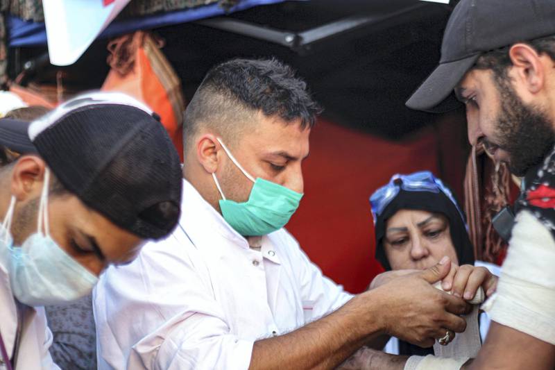 Medic Akeel Hani treats a protester injured on the Jumhuriya Bridge. Pesha Magid