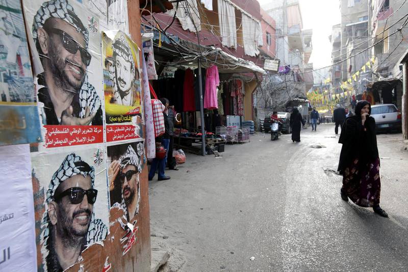 A picture taken on December 21, 2017 shows posters of late Palestinian leader Yasser Arafat plastered on a wall as residents walk past them down a street in the Burj al-Barajneh camp, a southern suburb of the Lebanese capital Beirut. - More than 174,000 Palestinian refugees live in Lebanon, authorities announced on December 21, in the first-ever census of its kind for a country where demographics have long been a sensitive subject.
The census was carried out by the government's Lebanese-Palestinian Dialogue Committee in 12 Palestinian camps as well as 156 informal "gatherings" across the country. (Photo by ANWAR AMRO / AFP)