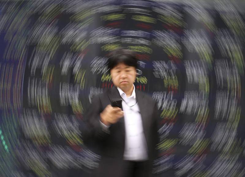 A man stands in front of an electronic stock board of a securities firm in Tokyo. Asian shares were mixed Monday amid continuing worries about tensions on the Korean Peninsula, while Hong Kong and Australian markets were closed for the Easter holidays. Koji Sasahara / AP Photo