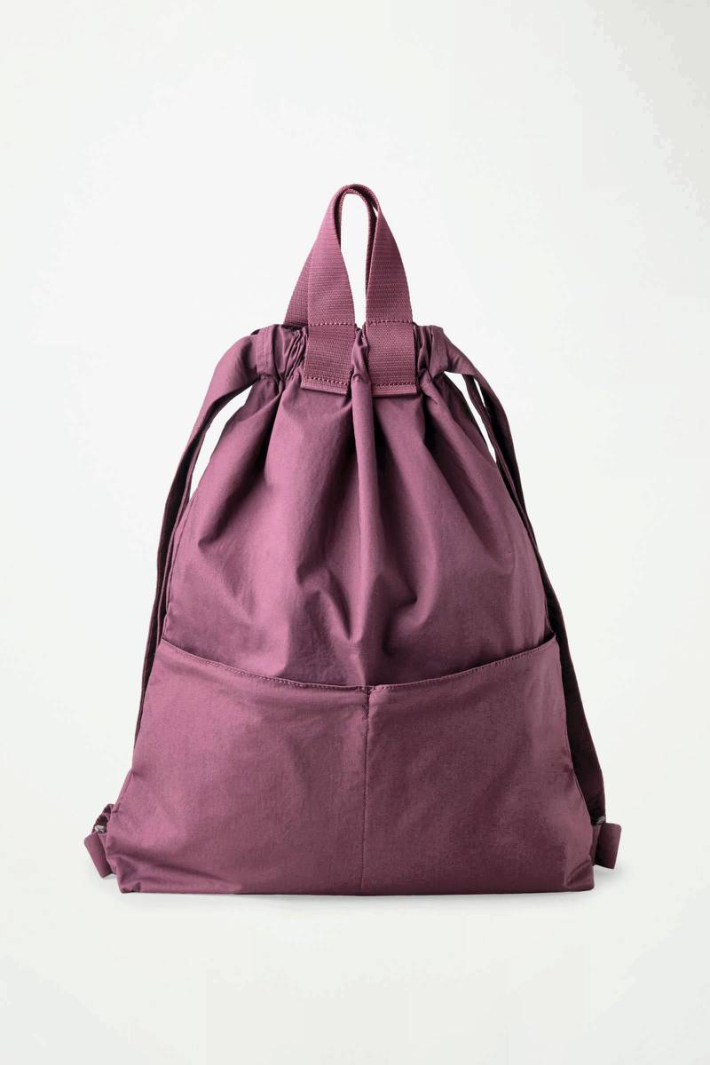 Cos bag, Dh257: A softly structured, cotton drawstring bag that can be worn in multiple ways. The burgundy shade is a knockout. This bag can be worn to your next weekend trip, or just as a winsome alternative to dull office backpacks