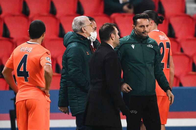 Istanbul Basaksehir coach Okan Buruk talks to fourth referee Sebastian Coltescu (R) after the game was suspended in the first half as the players walked off amid allegations of racism by one of the match officials. AFP