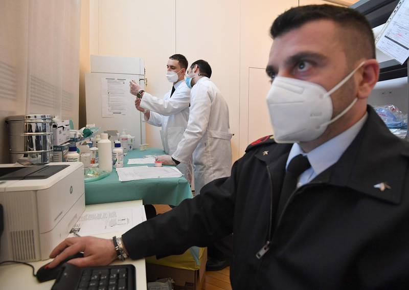 Two Air Force doctors prepare doses of vaccine at the new vaccination center set up at the Command of the 1st Air Region of the Italian Air Force in Milan, Italy. EPA