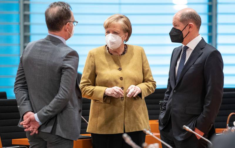 epa09132184 (L-R) Federal Foreign Minister Heiko Maas, German Chancellor Angela Merkel and German Finance Minister Olaf Scholz speak with each other at a cabinet meeting in Berlin, 13 April 2021. The German cabinet in its 137th session agreed on a change of the German Infection Protection law amid the coronavirus pandemic that would allow the implementation of countrywide counter-measures in case of a certain rate of infections. Both chambers of the German parliament still have to approve the amendment.  EPA/Andreas Gora / POOL