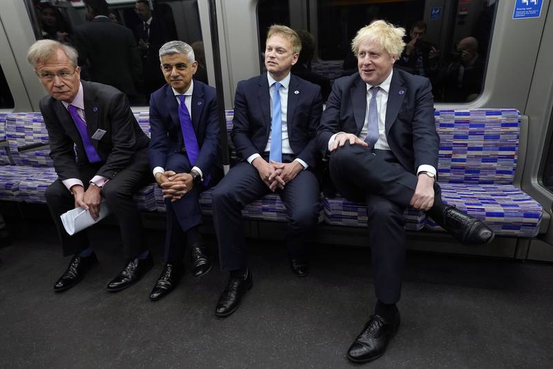 British Prime Minister Boris Johnson with Transport Secretary Grant Shapps, centre right, and Mayor of London Sadiq Khan, centre left, on an Elizabeth Line train at Paddington station. PA