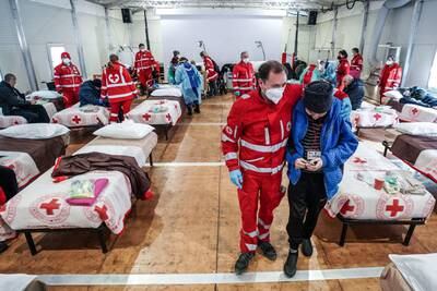 Ukrainian refugees, who arrived in Italy from Lviv after two weeks of travel, are tended to in the reception centre of the Red Cross in Settimo Torinese, near Turin. EPA