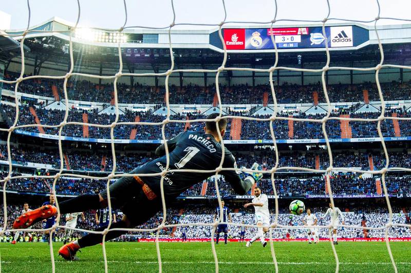 epa06561461 Real Madrid's French striker Karim Benzema (back C) scores the 4-0 lead from the penalty spot against Alaves' goalkeeper Fernando Pacheco (front) during the Spanish Primera Division soccer match between Real Madrid and Deportivo Alaves at Santiago Bernabeu stadium in Madrid, Spain, 24 February 2018.  EPA/RODRIGO JIMENEZ