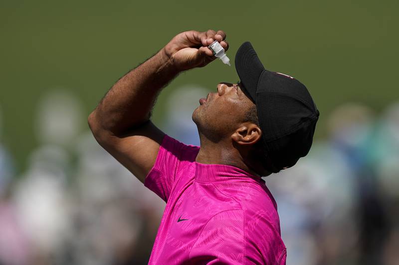 Tiger Woods uses eye drops on the seventh green. AP