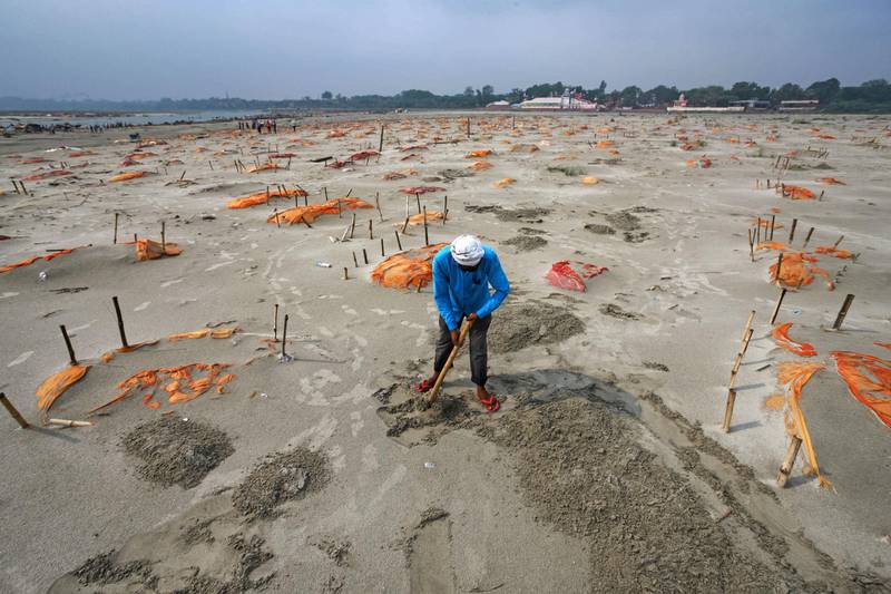 Bodies, some of which are believed to be Covid-19 victims, are seen partially exposed in shallow sand graves after rains washed away the top layer of sand at a cremation ground on the banks of the Ganges River in Shringverpur, north-west of Allahabad, Uttar Pradesh. Getty Images