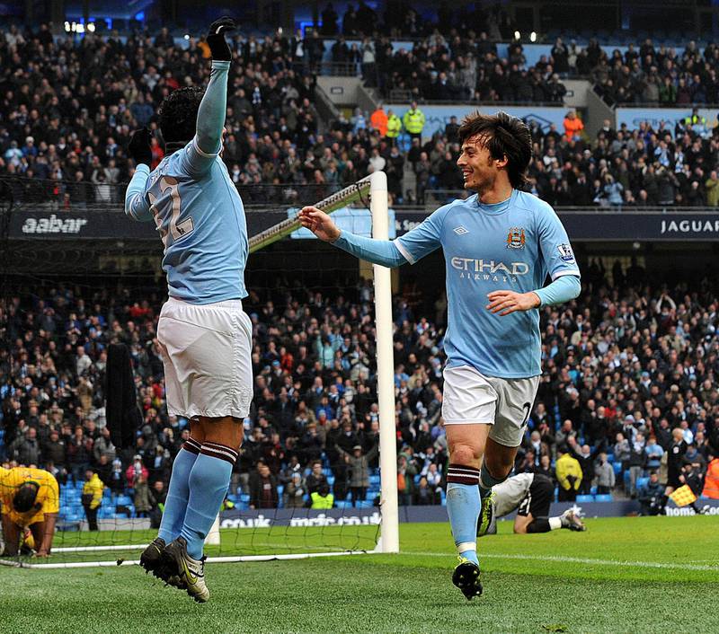 Manchester City's Argentinian forward Carlos Tevez (L) celebrates with Spanish midfielder David Silva (R) after scoring against Notts County's during the FA Cup fourth round replay football match between Manchester City and Notts County at the City of Manchester Stadium in Manchester, north-west England on February 20, 2011. AFP PHOTO/ BEN STANSALL RESTRICTED TO EDITORIAL USE Additional licence required for any commercial/promotional use or use on TV or internet (except identical online version of newspaper) of Premier League/Football League photos. Tel DataCo +44 207 2981656. Do not alter/modify photo (Photo by BEN STANSALL / AFP)