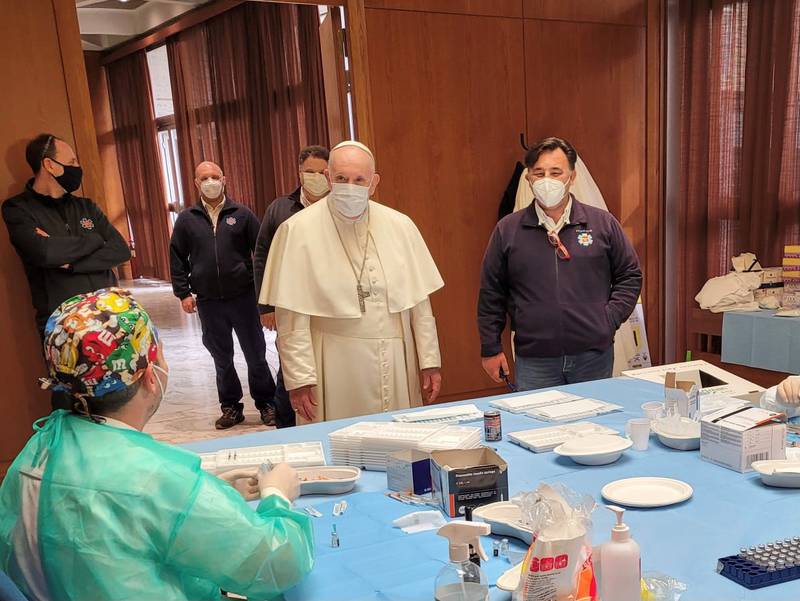 Pope Francis speaks to medical staff during a visit on Good Friday to a Vatican vaccination centre where the poor and homeless are being inoculated, on April 2, 2021. Vatican Media via Reuters