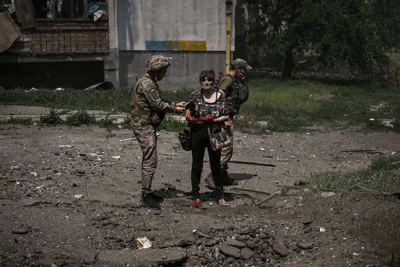 A wounded woman is assisted by Ukrainian soldiers in Lysychansk. AFP