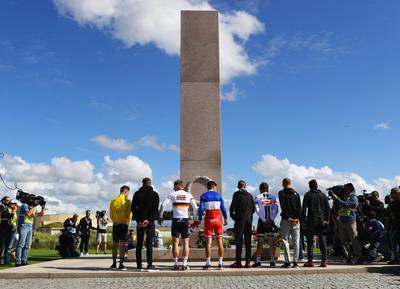 Stage winner Mark Cavendish of Great Britain and Team Dimension Data (R) and fellow riders observe a minutes silence at a war memorial at Utah Beach after Stage 1 of Le Tour de France 2016 on July 2, 2016 in Sainte-Marie-du-Mont, France. Bryn Lennon / Getty Images