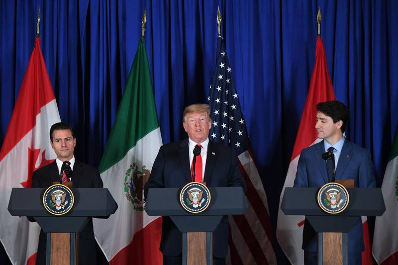 (L to R) Mexican President Enrique Pena Nieto, US President Donald Trump and Canadian Prime Minister Justin Trudeau deliver a statement on the signing of a new free trade agreement in Buenos Aires, on November 30, 2018, on the sidelines of the G20 Leaders' Summit. The revamped accord, called the US-Mexico-Canada Agreement (USMCA), looks a lot like the one it replaces. But enough has been tweaked for Trump to declare victory on behalf of the US workers he claims were cheated by NAFTA. / AFP / Martin BERNETTI

