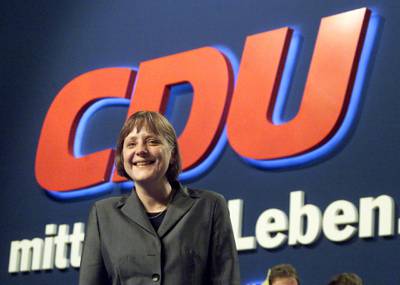 Angela Merkel poses under a CDU logo at the end a CDU party convention in Essen, April 11, 2000. Reuters