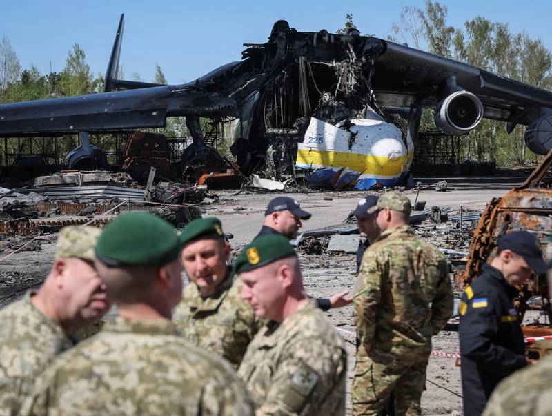 Ukrainian soldiers stand in front of the destroyed plane.  Reuters