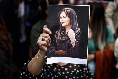 A protester holds a portrait of Mahsa Amini during a demonstration in front of the Iranian embassy in Brussels on September 23, 2022. AFP