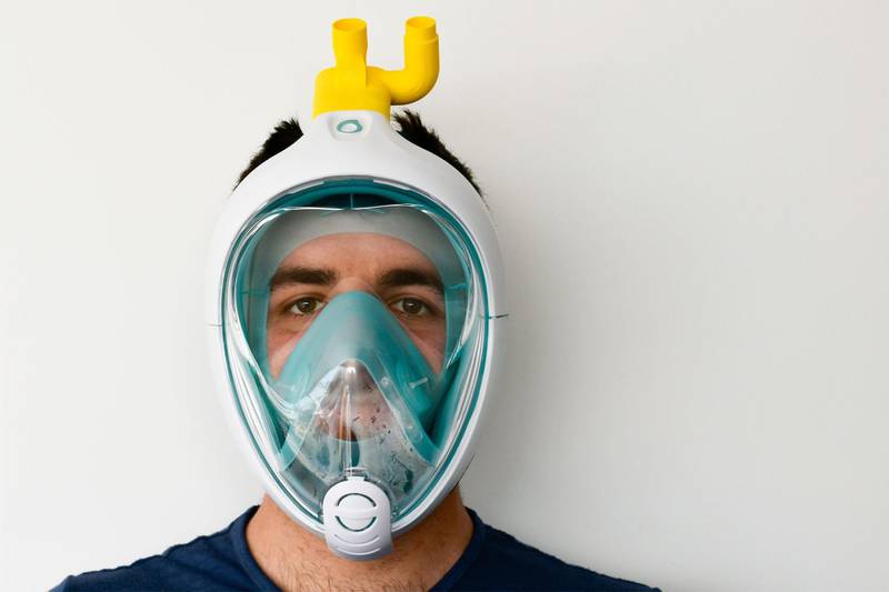 An undated photo taken in Brescia, Lombardy, and handout on March 24, 2020 by Italian engineering and design startup Isinnova shows young Italian engineer Alessandro Romaioli wearing a common snorkeling mask transformed into an emergency respiratory mask with 3D-printed respirator valve parts (Top), during the country's lockdown following the COVID-19 new coronavirus pandemic.  They may not be a miracle cure or a vaccine, but respirator valves from 3-D printers have helped coronavirus patients breathe a little easer in the Italian epicentre of COVID-19. - RESTRICTED TO EDITORIAL USE - MANDATORY CREDIT "AFP PHOTO / ISINNOVA" - NO MARKETING - NO ADVERTISING CAMPAIGNS - DISTRIBUTED AS A SERVICE TO CLIENTS
 / AFP / ISINNOVA / Handout / RESTRICTED TO EDITORIAL USE - MANDATORY CREDIT "AFP PHOTO / ISINNOVA" - NO MARKETING - NO ADVERTISING CAMPAIGNS - DISTRIBUTED AS A SERVICE TO CLIENTS
