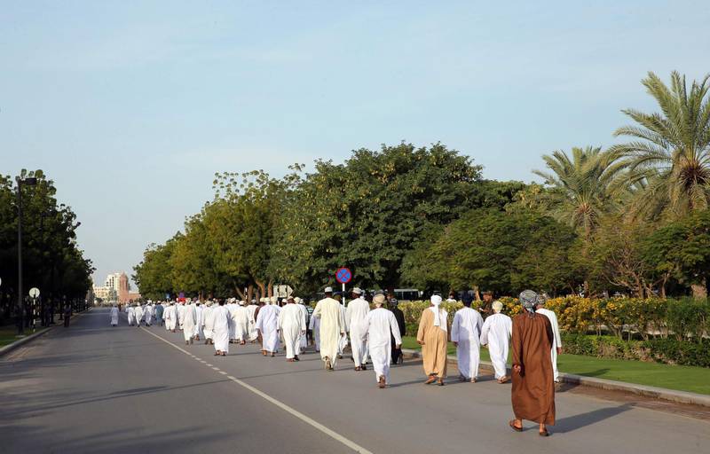 People walk towards the Sultan Qaboos Mosque to perform the funeral prayers. AFP