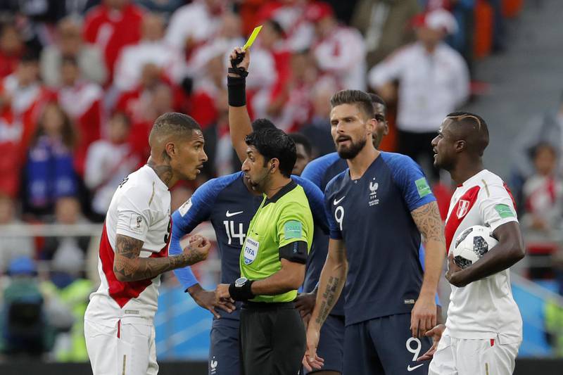 Referee Mohammed Abdulla Mohamed from the United Arab Emirates, second left, shows the yellow card to Peru's Paolo Guerrero, left. Vadim Ghirda / AP Photo