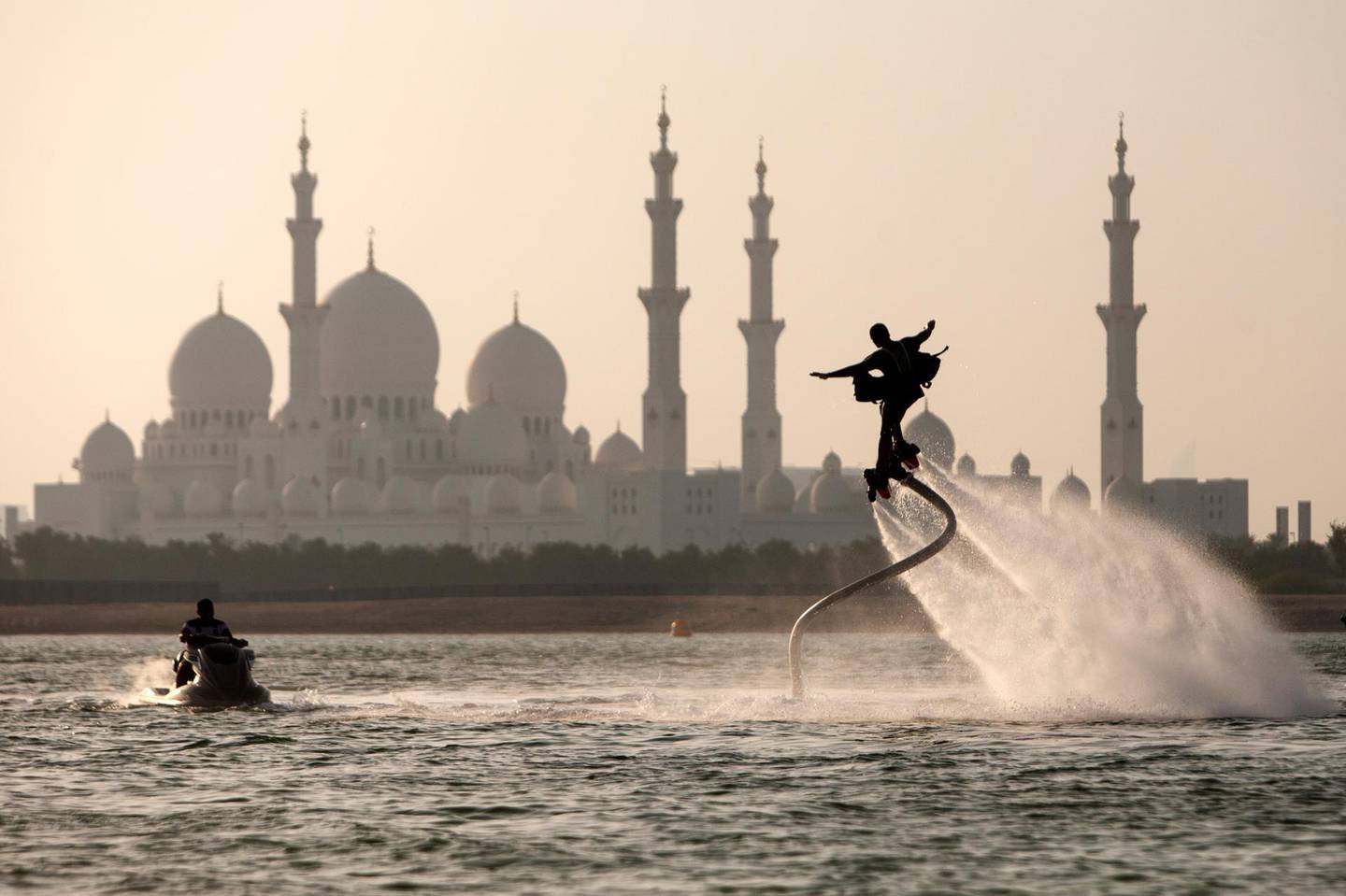 Abu Dhabi, United Arab Emirates, September 1, 2014:     A man flyboards in the Al Maqta Channel in front of the Sheikh Zayed Grand Mosque in Abu Dhabi on September 1, 2014. A Flyboard is a type of water jet-pack attached to a personal water craft which supplies propulsion to drive the device through air and water. Christopher Pike / The NationalReporter:  N/ASection: NewsPossible focal point