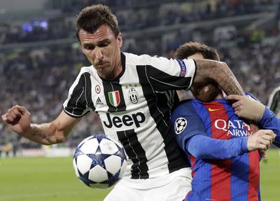 Juventus's Mario Mandzukic, left, and Barcelona's Lionel Messi vie for the ball. Antonio Calanni / AP Photo