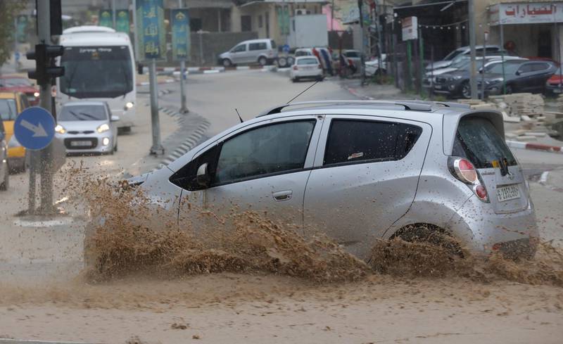 A Palestinian drives his car during a rain storm in Nablus. EPA