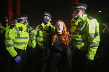 Police detain a woman as people gather at a memorial site in Clapham Common Bandstand, following the kidnap and murder of Sarah Everard, in London, Britain March 13, 2021. REUTERS/Hannah McKay