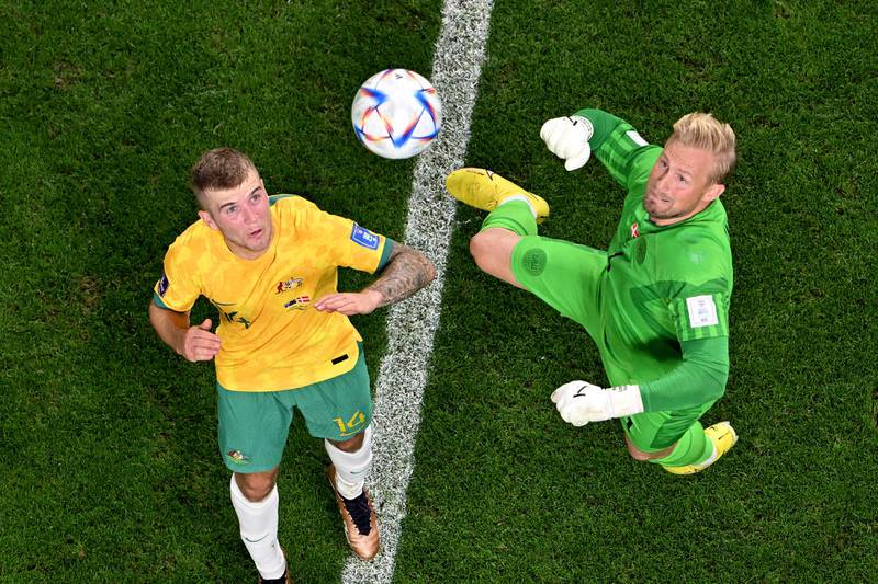 Denmark goalkeeper Kasper Schmeichel and Riley McGree keep their eyes on the ball. AFP