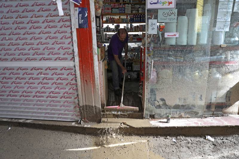 A shopkeeper clears up after the flood. AP Photo
