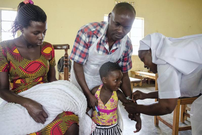 A child reacts as he receives an injection during the nationwide vaccination campaign against measles, rubella and polio targeting all children under 15 years old in Nkozi town, about 84 km from the capital Kampala, on October 19, 2019. - Uganda's Ministry of health with WHO and UNICEF aim to immunize more than 18 million children in Uganda which is about 43 percent of the population during their 5-day vaccination campaign. (Photo by Badru KATUMBA / AFP)