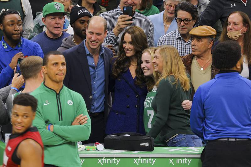 Fans take photographs with the royal couple during the game. AP