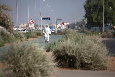 ABU DHABI, UNITED ARAB EMIRATES, Sep. 25, 2014:  
A man heads out for a walk along the Salaam Street near where it meets 19th (Al Sa'ada Street) in an area landscaped in a new desert-style, with low-water consumption plants and a marked absence of irrigation, on Thursday, Sep. 25, 2014. On the other side of the Salaam Street is a green and lush traditional park space features expansive grass area, a dolphin fountain and palm trees. (Silvia Razgova / The National)

Usage: Sep. 28, 2014
Section: WK
Reporter:  Nick Leech

