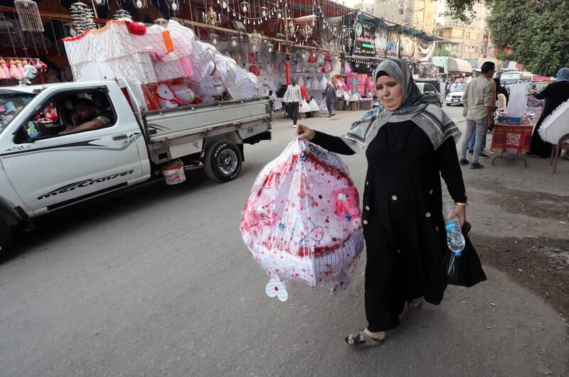An Egyptian woman with a sweet doll for the upcoming Mawlid celebrations (Prophet Mohammed's birthday), at a market in Sayeda Zienab district in Cairo. The decoration of dolls for this occasion in Egypt is believed to date back to the time of the Fatimid dynasty. EPA