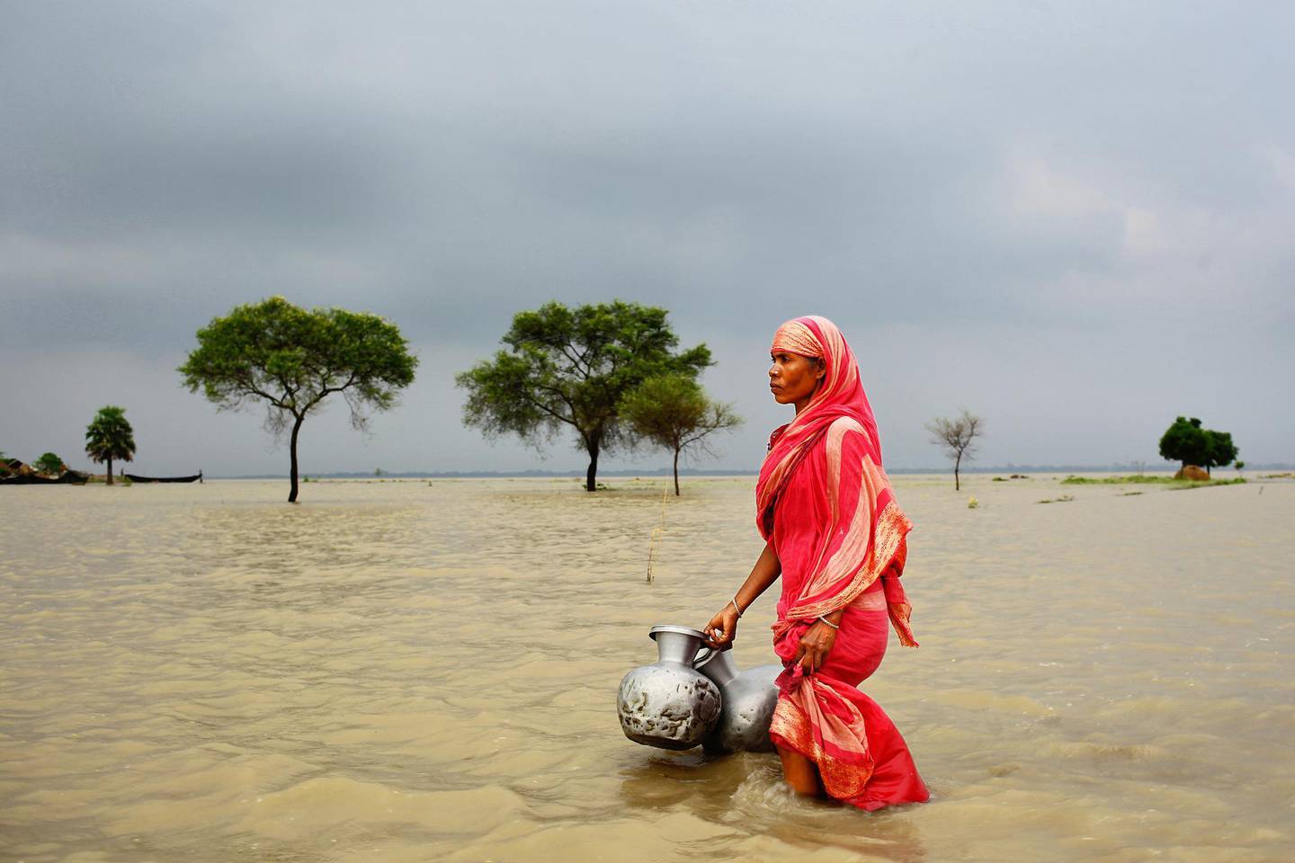 “Water, water everywhere, not any drop to drink.” Climate victim Rahima Khatun (49) lives at Khanpur village in Rajshahi, Bangladesh. Her only deep tube well has been flooded and everyday she has to go to another village to collect pure drinking water. 1. Dacca Bangladesh Hte DEF _@Yusuf Ahmed_IMG_6838_Climate Victim. Courtesy Alliance Francaise Dubai *** Local Caption ***  rv04ju-edspick.jpg