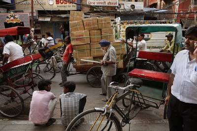 An elderly Sikh man, center, checks his mobile phone as he walks through a busy street in New Delhi, India. Manish Swarup / AP Photo