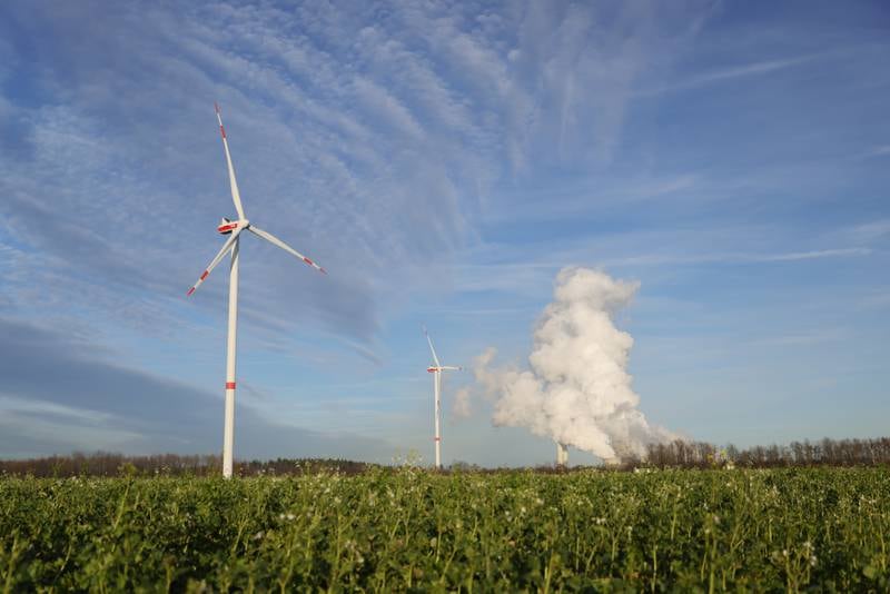 Wind turbines stand as steam rises from cooling towers of the Niederaussem coal-fired power plant near Bergheim, Germany, last week. Getty Images