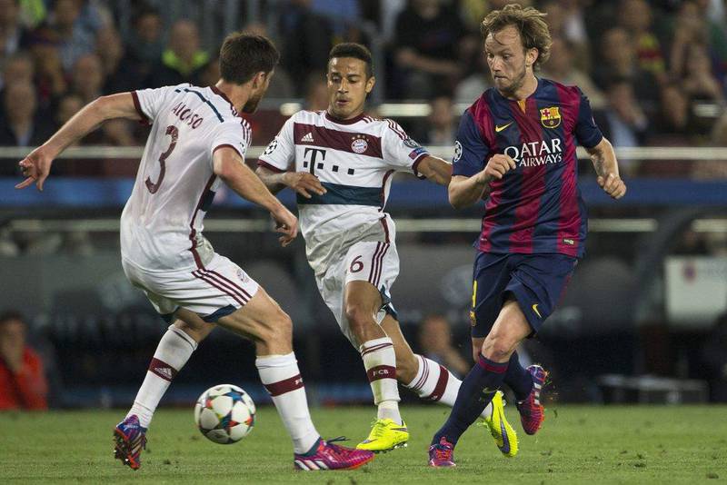 Ivan Rakitic of Barcelona vies for the ball with Bayern Munich's Xabi Alonso, left, and Thiago Alcantara, centre, on Wednesday during their Champions League contest. Alejandro Garcia / EPA