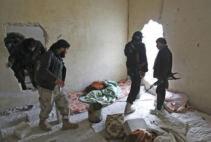 Members of Islamist Syrian rebel group Jabhat Al Nusra carry their weapons as they move through a hole in a wall near Aleppo international airport on January 28. Ammar Abdullah/Reuters